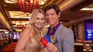 Couple on casino floor showing Infinity Rewards cards